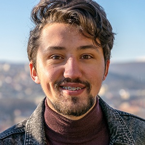 Portrait of smiling man with braces, standing outside