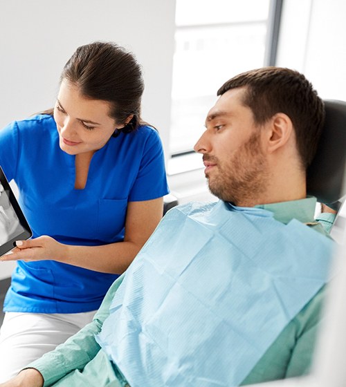 A male patient looking at his dental X-Rays on a tablet