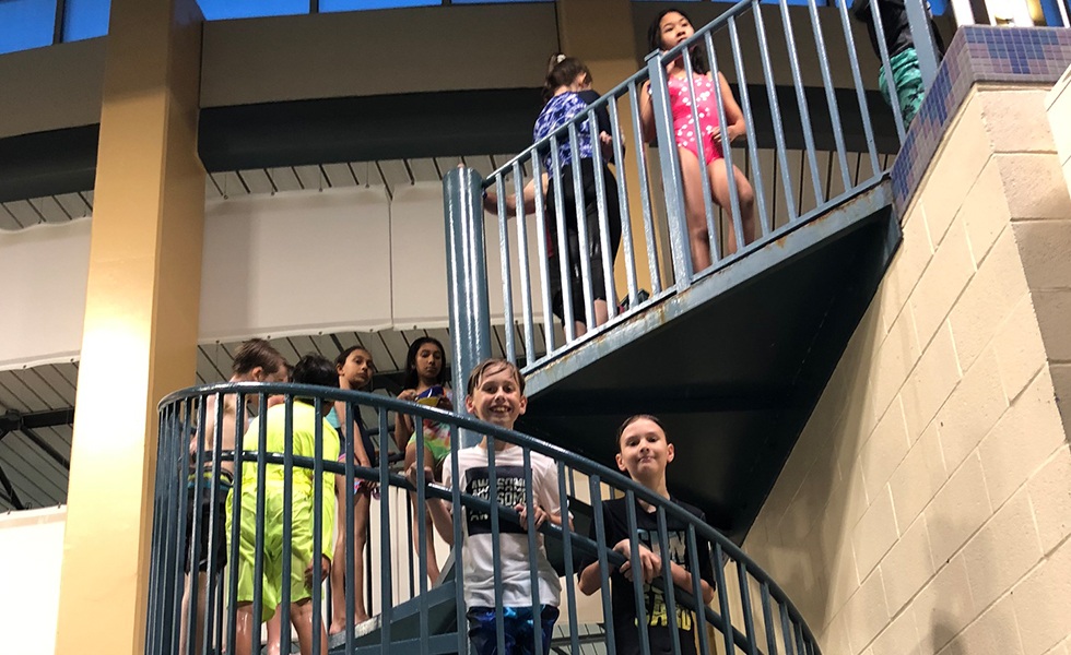 Kids walking up stairs at community pool party event