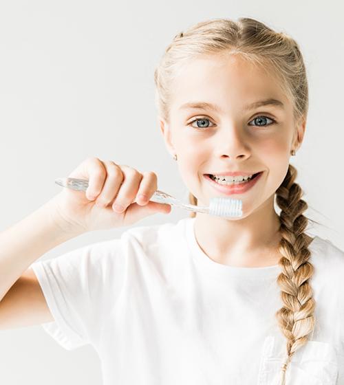 Happy blond girl holding a toothbrush