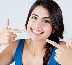 young woman pointing to smile