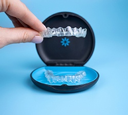 closeup of person holding Invisalign aligner 