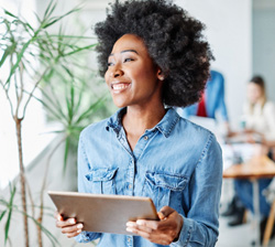 Smiling woman holding tablet in office