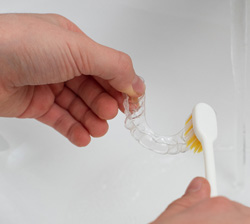 Patient cleaning clear aligner with toothbrush