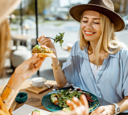 Smiling friends enjoying meal outside