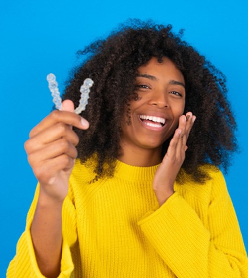 teen holding Invisalign tray 