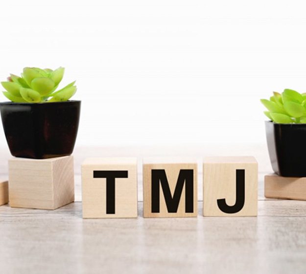 several wooden blocks spelling T M J