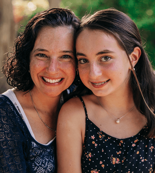 Teen girl with braces and her mom smiling together