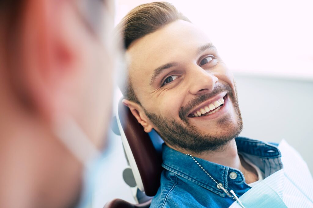 Man with straight teeth smiling at orthodontist