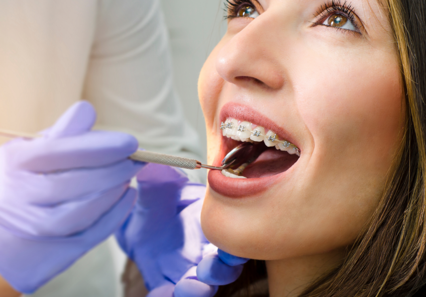 Woman with braces undergoing dental exam.